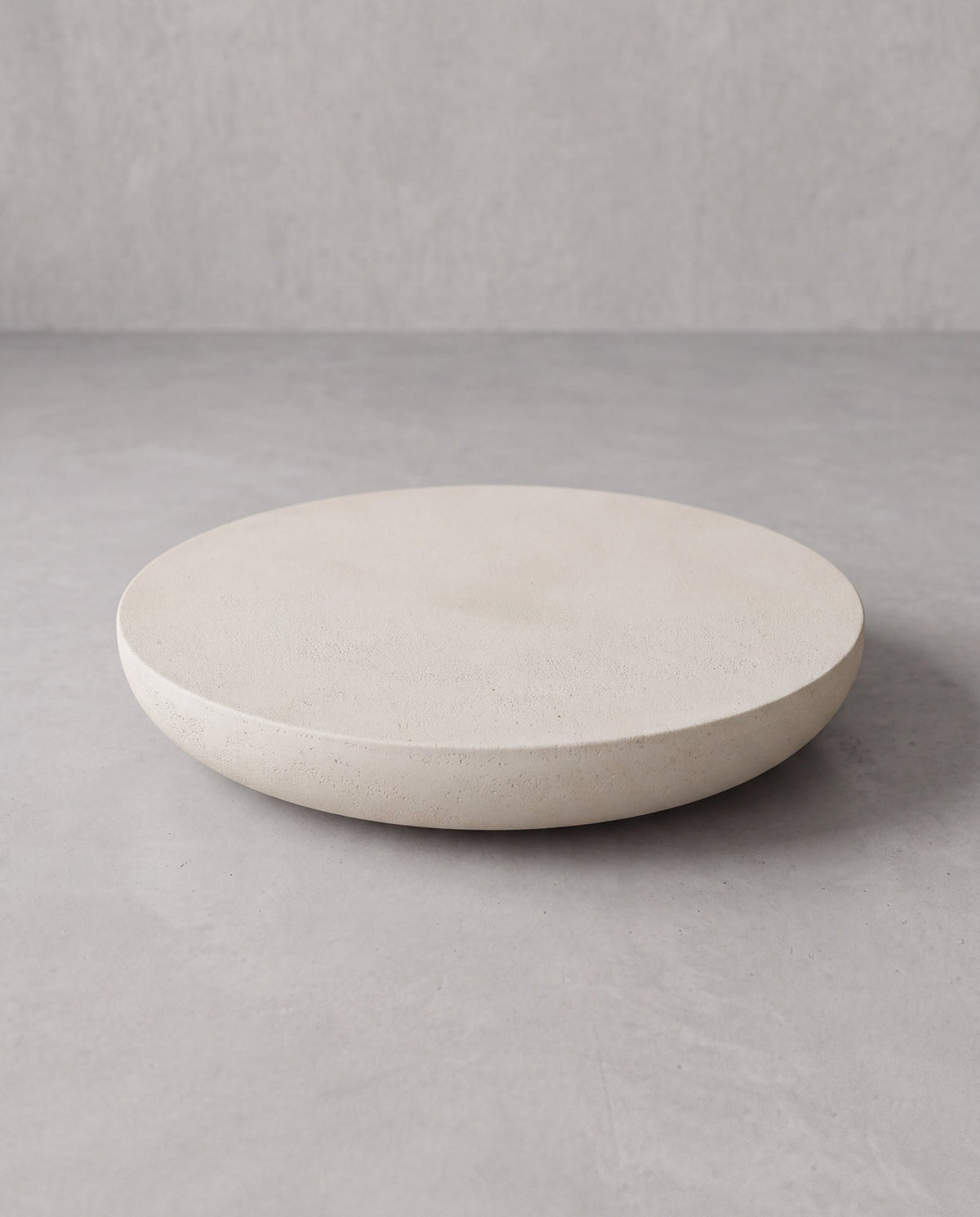 LUMA 03 – low sculptural table in warm off-white with a textured stone-effect finish