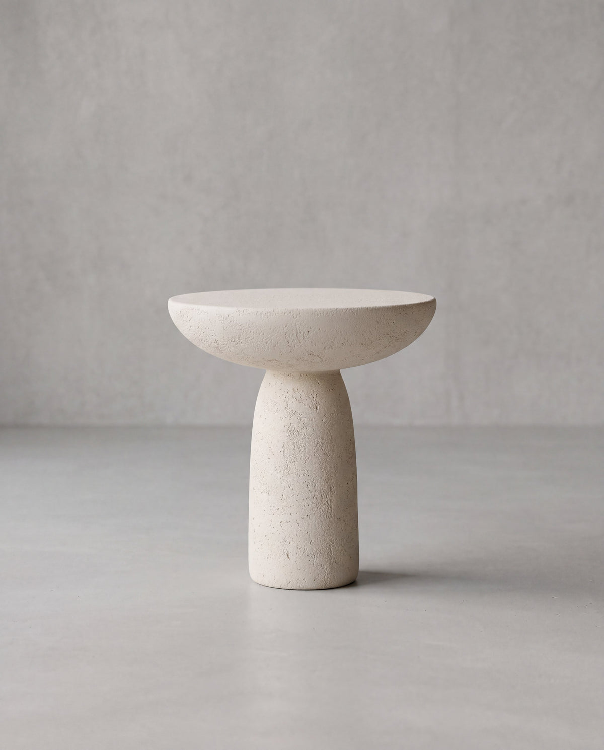 LUMA 01 – high sculptural table in warm off-white with a textured stone-effect finish