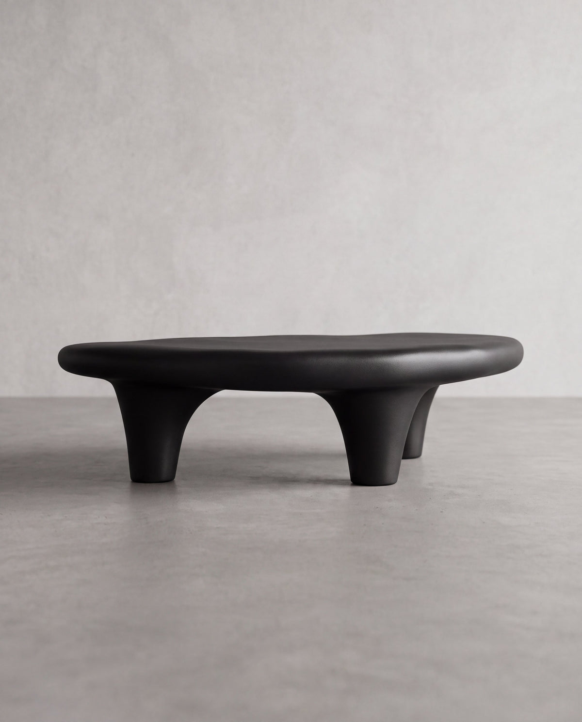 KANO Coffee Table – angled view of the matte black organic form and sculptural legs
