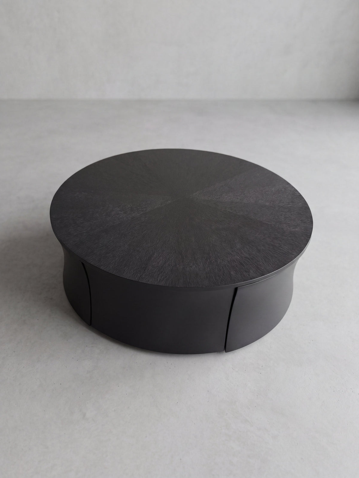AKI Coffee Table – round matte black fiberglass coffee table with wood detailing